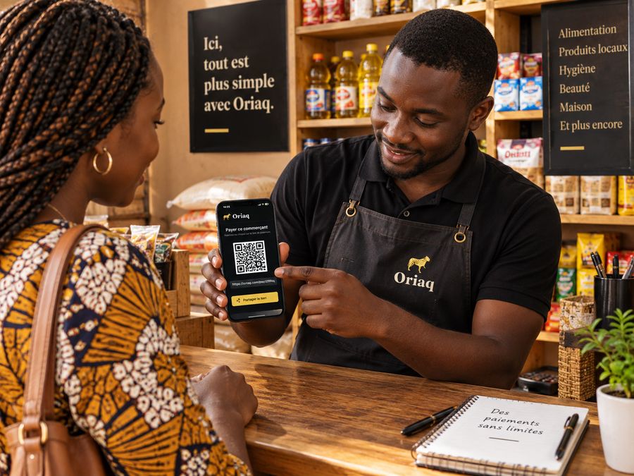 Un commerçant montre à sa cliente le code de paiement sur son téléphone